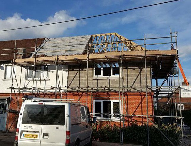 House with scaffolding around it, roof being repaired